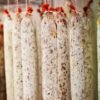 Close up of Chorizo sausages hanging from hooks in a charcuterie.