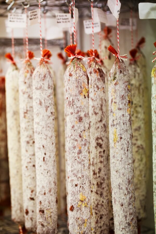 Close up of Chorizo sausages hanging from hooks in a charcuterie.