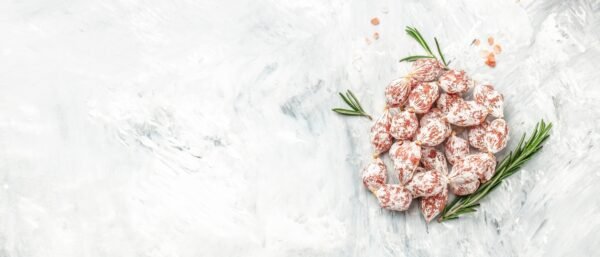 Cocktail Salami mini. spicy pork fermented dry cured sausages on a light background.